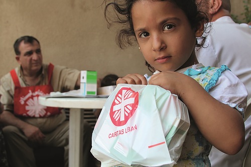 A doctor who mans a Caritas 'mobile clinic' examines Syrian refugee children in Baalbek, Lebanon. Many refugee families are living in unsanitary conditions; children come to the doctor because of diarrhea, coughing, lice, and other problems.In summer